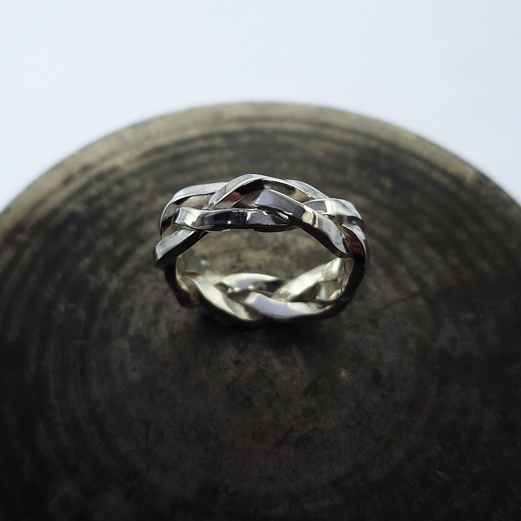 Triple braid silver ring on steel background