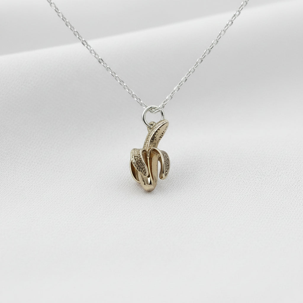 Gold and silver banana pendant on a white background