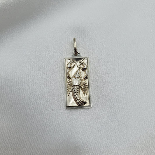 Silver pendant with lobster design on a gray background